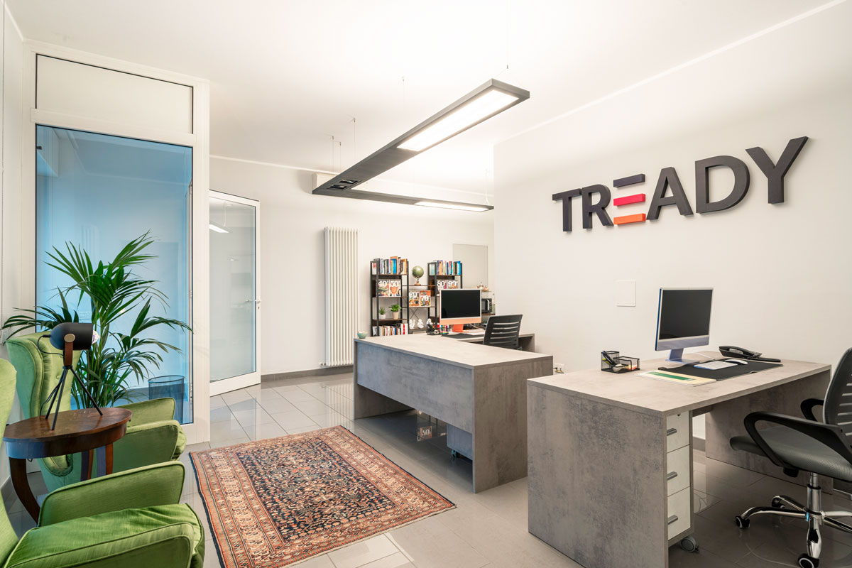 Reception della sede Tready a Lecco con logo a parete e area lounge