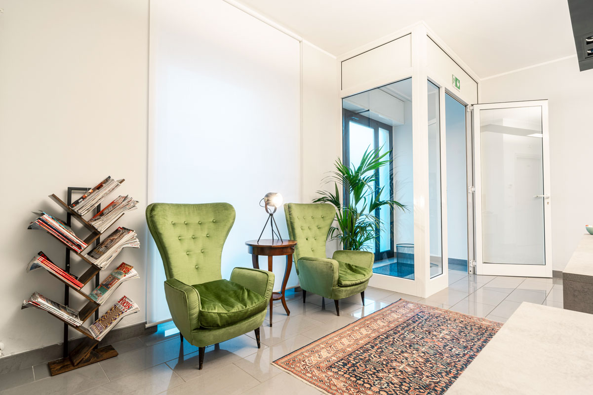 Area lounge Tready con poltrone verdi e cabina acustica